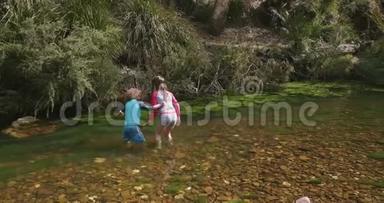 年轻的女孩扶着她的弟弟，<strong>因为</strong>他们在河河里的水中行走